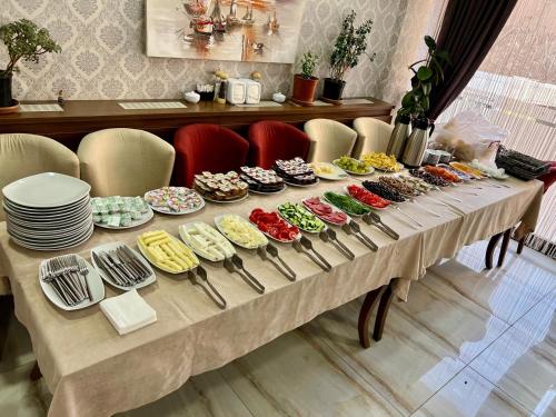 un lungo tavolo con piatti e ciotole di cibo di Zara Palas Otel a Zara