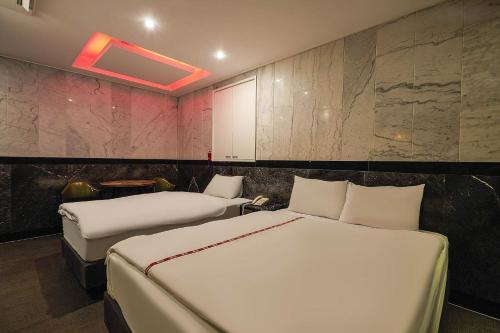 a hotel room with two beds and a wall with at Signature Tourist Hotel in Seoul