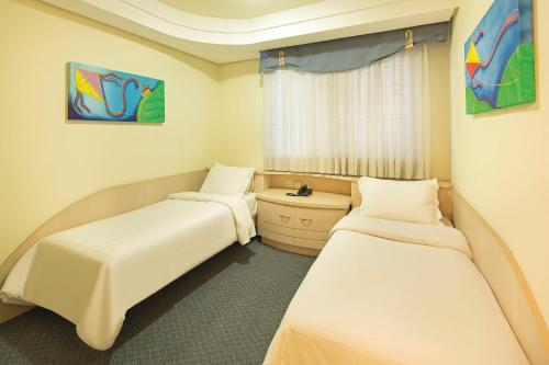 a room with two beds and a window at Swan Porto Alegre in Porto Alegre