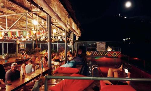 a group of people sitting on a boat at night at Outpost Hostel - Coron in Coron
