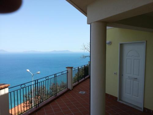 uma varanda com uma porta e vista para o oceano em Nicoletta em Piraino