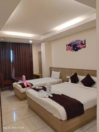 a hotel room with two beds and a desk at Hotel Swastik Inn in Gangtok