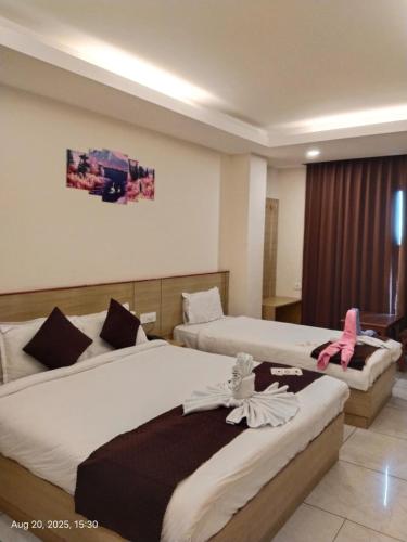 a hotel room with two beds in a room at Hotel Swastik Inn in Gangtok
