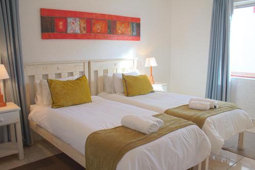 1 dormitorio con 2 camas y toallas. en Oceans Hotel & Self Catering en Mossel Bay