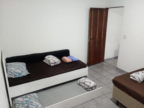 a room with a bed with two towels on it at kit net Vovó nice garagem gratis in Aparecida