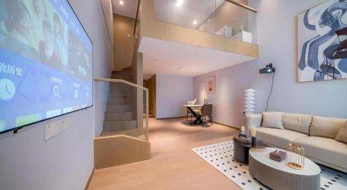 a living room with a couch and a large screen at F-TOWN Fangtang Hotel (Shenzhen Longgang Tian'an Digital City Huanggekeng Subway Station) in Shenzhen