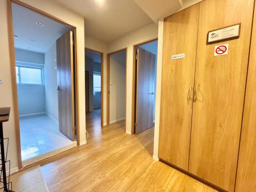 an empty hallway with wooden floors and glass doors at 北沢愛の旅 in Tokyo