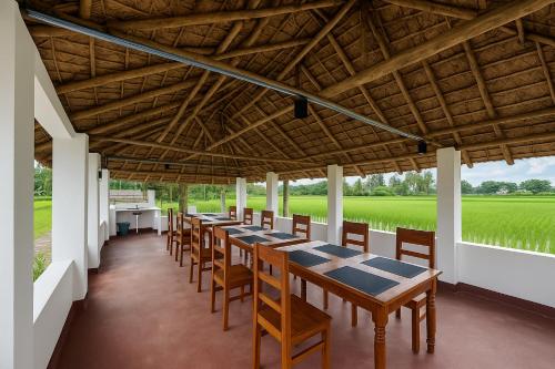 a row of tables and chairs under a wooden ceiling at Mangrove Forest Camp Eco Stay Sundarbans, India in Jāmb