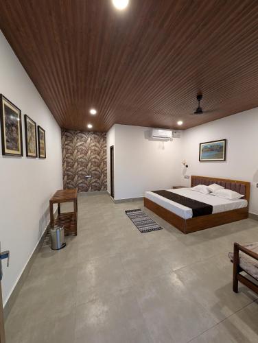 a bedroom with a bed and a wooden ceiling at Mangrove Forest Camp Eco Stay Sundarbans, India in Jāmb
