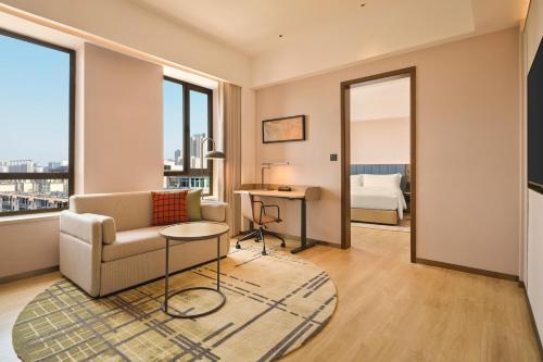 a living room with a couch and a table at Hilton Garden Inn Yingkou Zhanqian in Yingkou