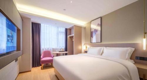 a hotel room with a large bed and a tv at Lavande Hotel Guangzhou Quzhuang Metro Station in Guangzhou
