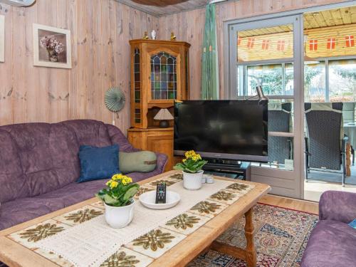 a living room with a purple couch and a tv at 9 person holiday home in Grenaa-By Traum in Grenå