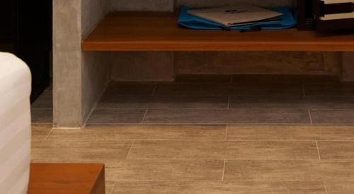 a wooden table sitting on top of a tile floor at Thalassa Hotel in Koh Tao