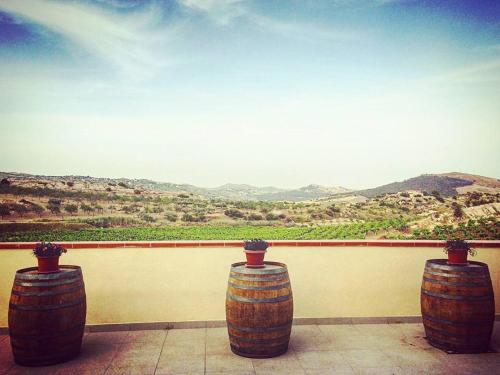 three wooden wine barrels sitting on a wall with a view at Agriturismo La Casa di Bacco in Agrigento