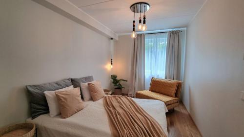 Un dormitorio con una cama, una silla y una ventana en Cozy Tartu Apple Garden with Terrace, en Tartu
