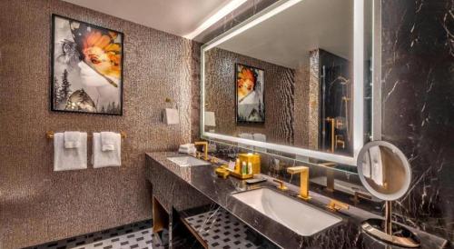 Atlantis Casino Resort Spa في رينو: حمام به مغسلتين ومرآة كبيرة