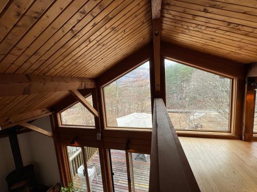a room with a large window in a cabin at Cabin D 3min walk Lake Saiko remote work BBQ, 5min drive Kawaguchi Lake Mt Fuji view in Narusawa