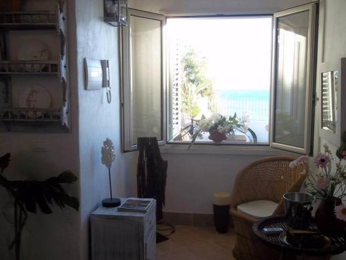アグリジェントにあるVilla Mare Di Montelusaの窓、椅子、テーブルが備わる客室です。