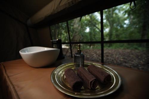 a plate of chocolate desserts on a table with a bowl at Kumana Under Canvas in Panama