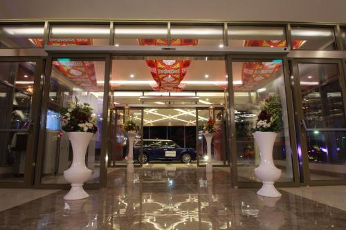 a building with three white vases with flowers in it at Novotel Yanbu Albahr in Yanbu
