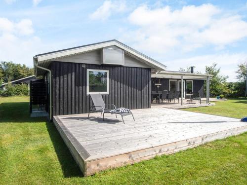 a building with a deck with a chair on it at 6 person holiday home in Tarm-By Traum in Tarm