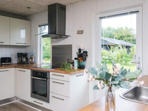 a kitchen with white cabinets and a sink and a window at 6 person holiday home in Tarm-By Traum in Tarm