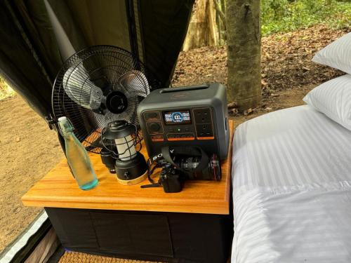 a fan and camera on a table next to a bed at Kumana Under Canvas in Panama
