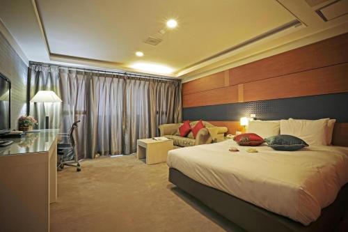 a hotel room with a bed and a couch at Metro Tourist Hotel Cheonan in Cheonan