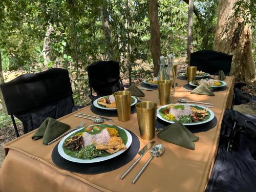 a long table with plates of food on it at Kumana Under Canvas in Panama