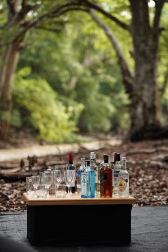 a table with glasses and bottles of alcohol on it at Kumana Under Canvas in Panama