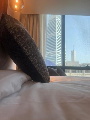 a pillow sitting on top of a bed with a window at VERTA Al Olaya Hotel in Riyadh