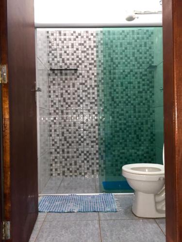 a bathroom with a glass shower with a toilet at Pousada Corazao Sagradao in Abadiânia