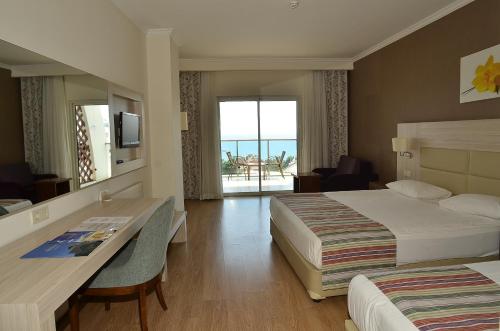a hotel room with two beds and a desk at Side Prenses Resort Hotel & Spa in Side
