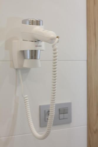 a white phone with a cord hanging from a wall at Hotel Perla in Benidorm