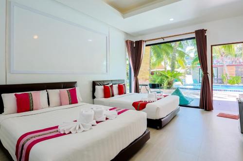 una camera da letto con due letti e una grande finestra di คินโจ พาร์ค รีสอร์ต - ใกล้วัดเจดีย์ ไอ้ไข่ ad Amphoe Sichon
