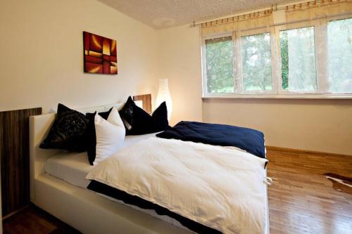 Schlafzimmer mit einem Bett mit schwarzen und weißen Kissen in der Unterkunft Guest House Šempeter in Šempeter v Savinjski Dolini