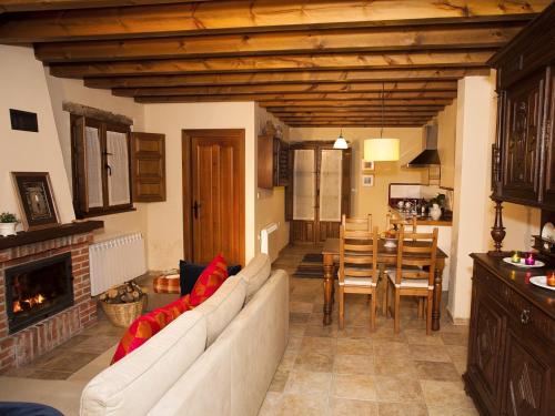 a living room with a white couch and a fireplace at Cozy Cottage with Pool & Terrace in Nava