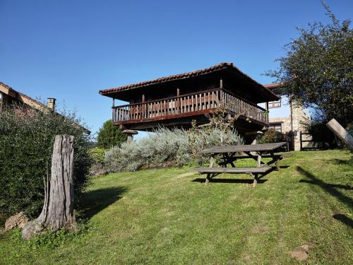 a picnic table in the grass in front of a building at Cozy Cottage with Pool & Terrace in Nava