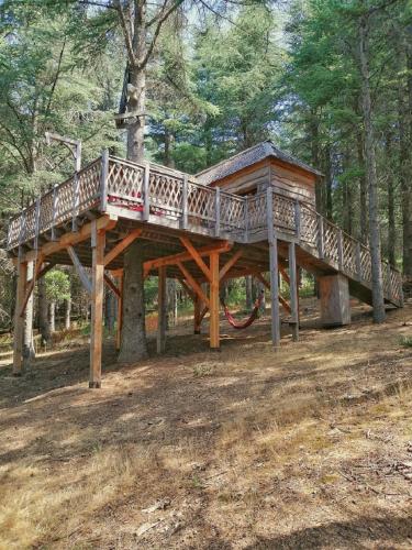 a wooden tree house in the middle of a forest at Cabane Écureuil & Cabane Chevreuil in Fournes-Cabardès