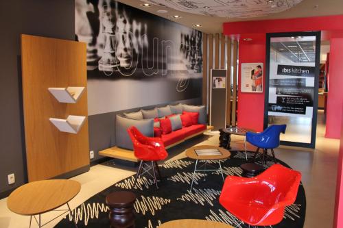 a lobby with red and blue chairs and a couch at ibis Chapeco in Chapecó