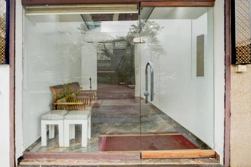 a glass door of a house with a chair and a table at Collection O Infopark Kochi Formerly Malabar Plaza Residency in Kakkanad