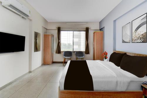 a bedroom with a large bed and two chairs at Super Collection O Katraj Bus Stop Formerly Indu Ville in Māngvādi