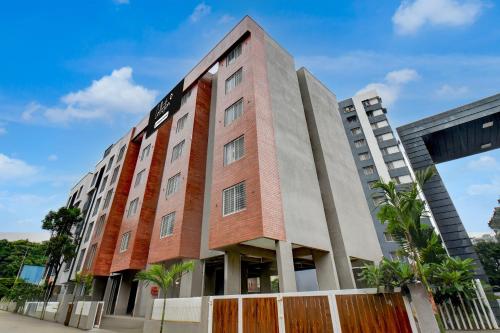 a red brick building with two tall buildings at Super Collection O Katraj Bus Stop Formerly Indu Ville in Māngvādi