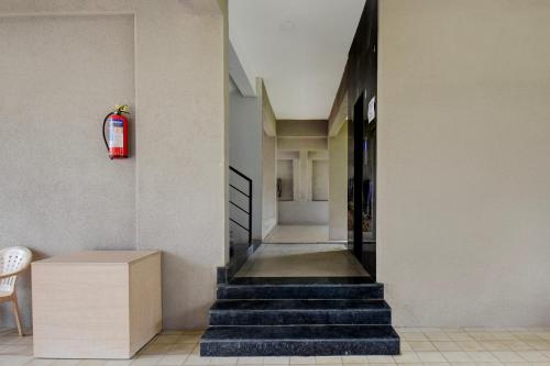 a hallway with stairs and a fire extinguisher at Super Collection O Katraj Bus Stop Formerly Indu Ville in Māngvādi