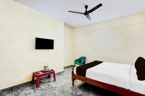 a bedroom with a bed and a ceiling fan at Super Collection O Sathyabama University Sithalapakkam Formerly Srinivasa Residency in Chennai