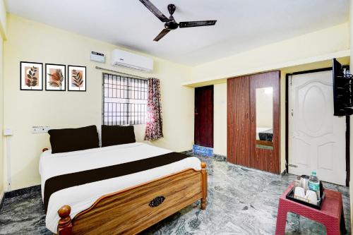 a bedroom with a bed and a ceiling fan at Super Collection O Sathyabama University Sithalapakkam Formerly Srinivasa Residency in Chennai