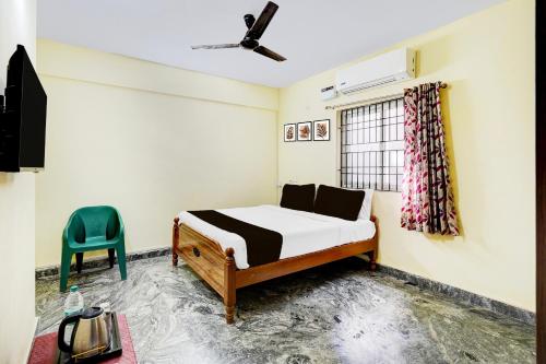 a bedroom with a bed and a blue chair at Super Collection O Sathyabama University Sithalapakkam Formerly Srinivasa Residency in Chennai
