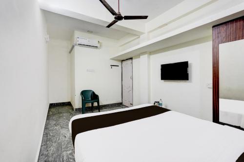 a bedroom with a bed and a tv on the wall at Super Collection O Sathyabama University Sithalapakkam Formerly Srinivasa Residency in Chennai
