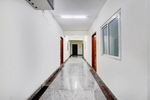 a corridor of a room with white walls and a window at Super Collection O Sathyabama University Sithalapakkam Formerly Srinivasa Residency in Chennai