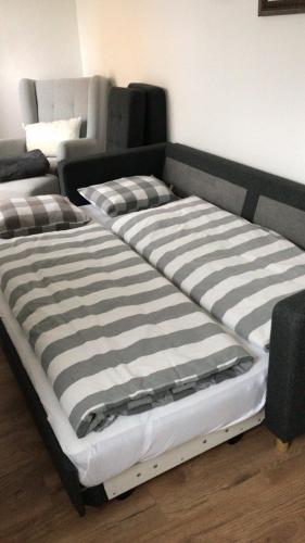 a large bed with a black and white striped mattress at Ferienwohnung Gmunden City in Gmunden